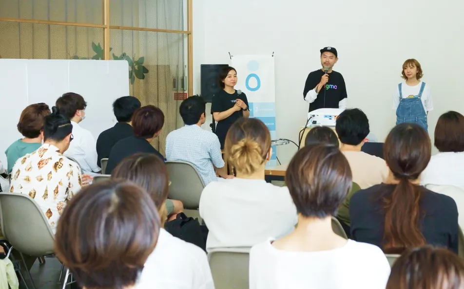 イベント会場で観客に向けて3人の登壇者が話している様子